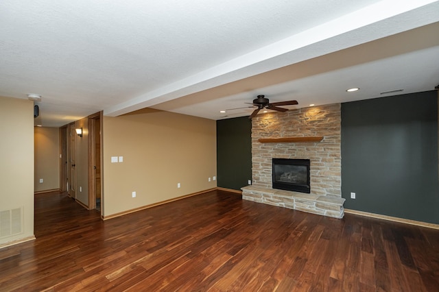 424 11th St NW, Byron, MN 55920 - unfurnished living room with a stone fireplace, visible vents, wood finished floors, and ceiling fan