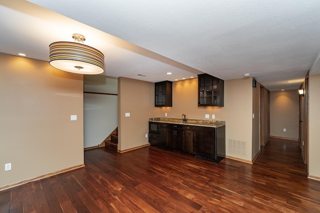424 11th St NW, Byron, MN 55920 - kitchen with glass insert cabinets, visible vents, baseboards, and dark wood-type flooring