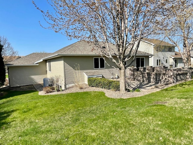 424 11th St NW, Byron, MN 55920 - rear view of property featuring central AC unit, roof with shingles, and a lawn