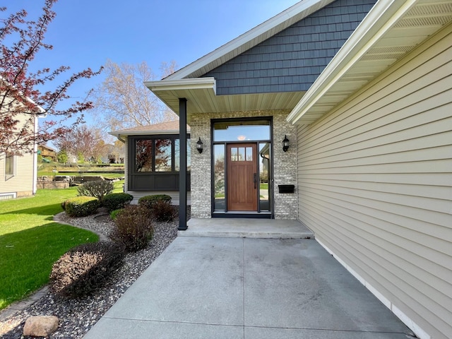 424 11th St NW, Byron, MN 55920 - doorway to property with a yard, brick siding, and a porch
