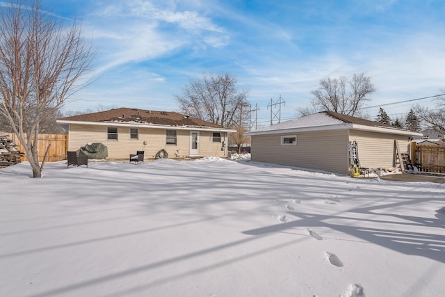 snow covered house featuring fence