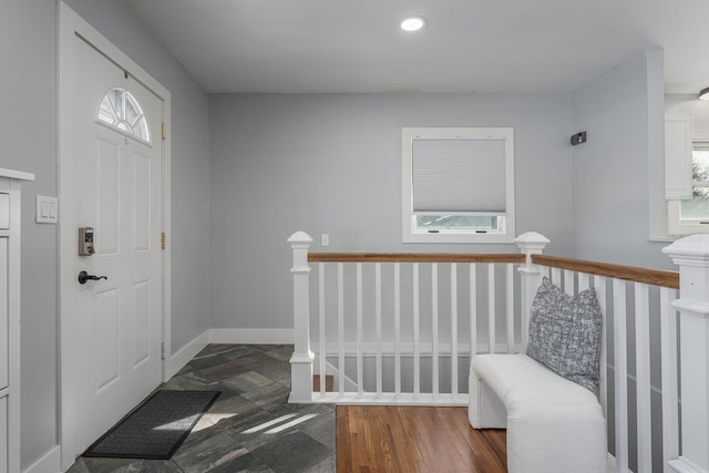 foyer entrance featuring recessed lighting, stone finish flooring, and baseboards