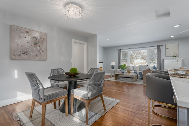 dining space featuring recessed lighting, baseboards, and wood finished floors