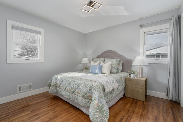 bedroom featuring visible vents, baseboards, and wood finished floors