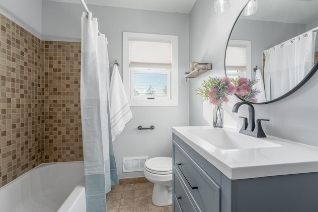 bathroom featuring visible vents, toilet, vanity, and shower / bath combination with curtain