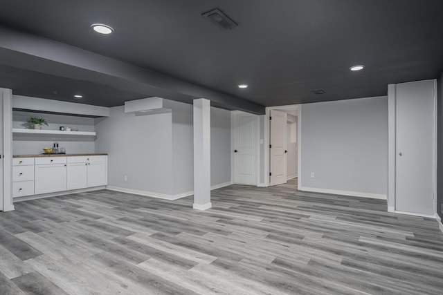 finished basement with recessed lighting, light wood-style floors, visible vents, and baseboards