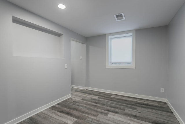 spare room featuring dark wood-style floors, baseboards, and visible vents