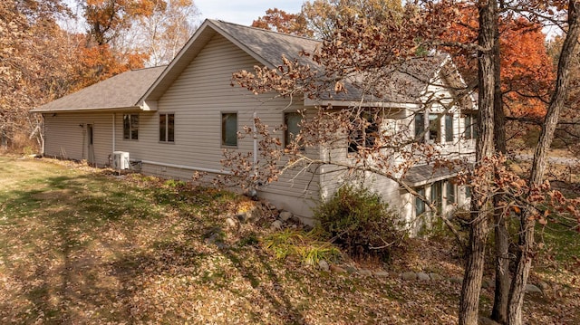 exterior space with a yard and roof with shingles