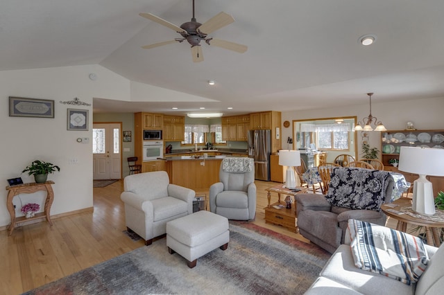 living room featuring ceiling fan with notable chandelier, vaulted ceiling, recessed lighting, and light wood-style floors