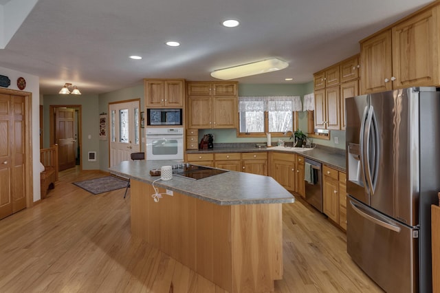 kitchen with a breakfast bar, a sink, recessed lighting, stainless steel appliances, and light wood-style floors