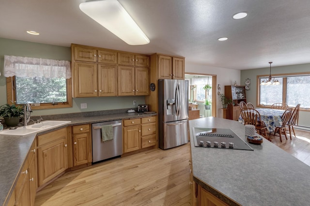 kitchen with dark countertops, light wood-type flooring, recessed lighting, stainless steel appliances, and a sink