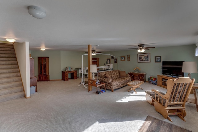 carpeted living room with stairs and a ceiling fan