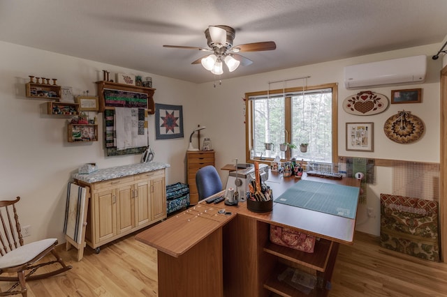 office area featuring an AC wall unit, light wood-style flooring, and a ceiling fan