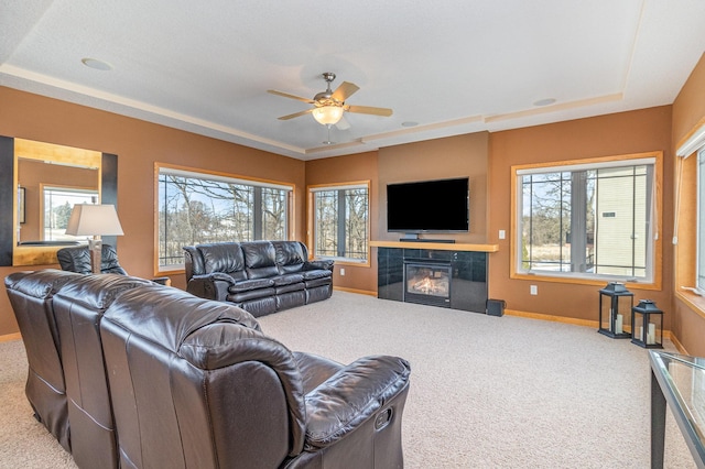 living room featuring a wealth of natural light, a tile fireplace, and carpet floors