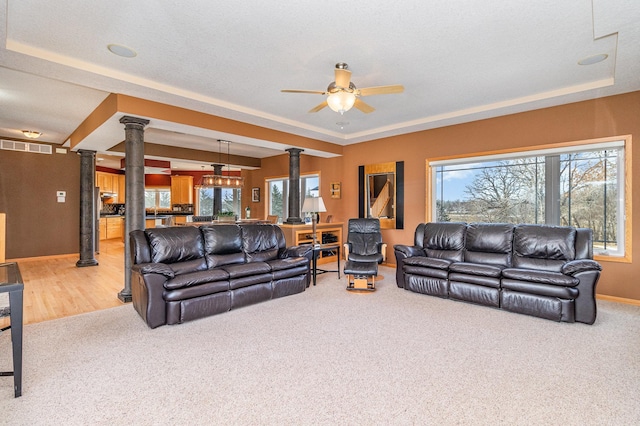 living room featuring a wealth of natural light, carpet flooring, and ornate columns