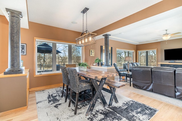 dining room with ceiling fan, decorative columns, baseboards, and wood finished floors