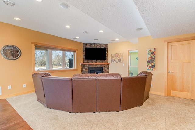 living area with a textured ceiling, recessed lighting, baseboards, and a large fireplace