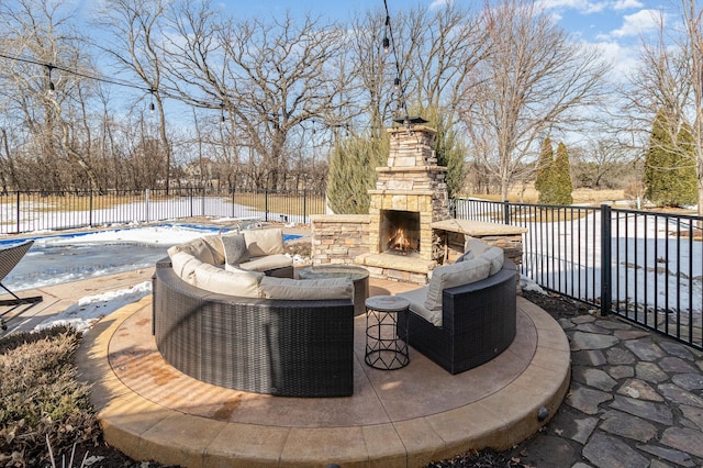 view of patio / terrace with an outdoor living space with a fireplace, fence, and a fenced in pool