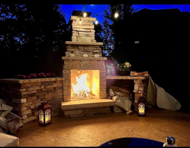 exterior details with concrete driveway and a fireplace