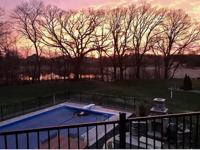 view of swimming pool featuring a patio area, a fenced in pool, fence, and a diving board