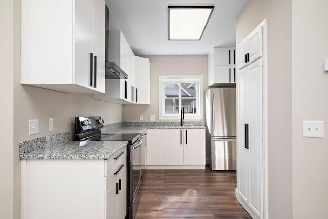 kitchen with electric range oven, freestanding refrigerator, dark wood-style floors, white cabinetry, and a sink