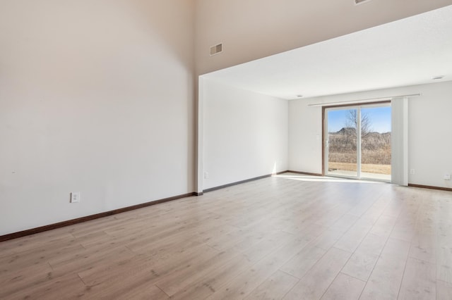 spare room with visible vents, baseboards, and light wood-style flooring