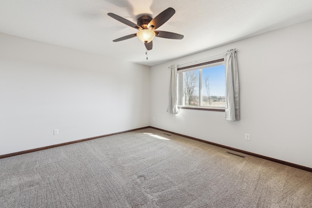 carpeted empty room featuring ceiling fan, baseboards, visible vents, and a textured ceiling