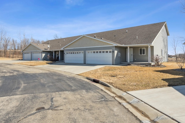 ranch-style house with an attached garage, concrete driveway, and roof with shingles