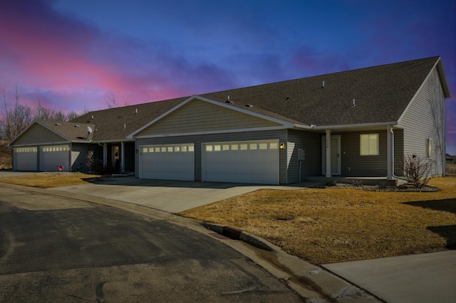 single story home featuring concrete driveway and an attached garage