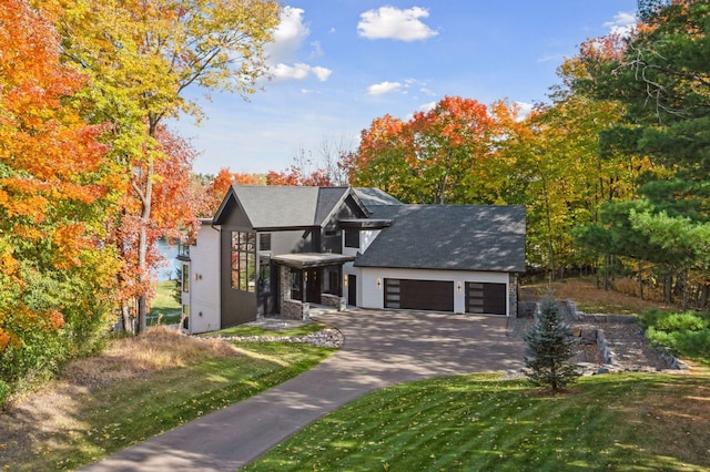 view of front of home featuring a garage, driveway, and a front yard