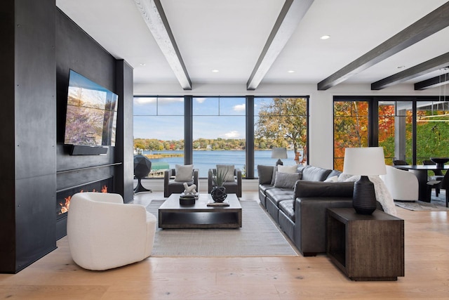 living room featuring beam ceiling, recessed lighting, wood finished floors, and a large fireplace