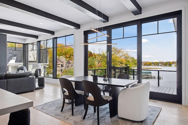 sunroom with beamed ceiling and a water view