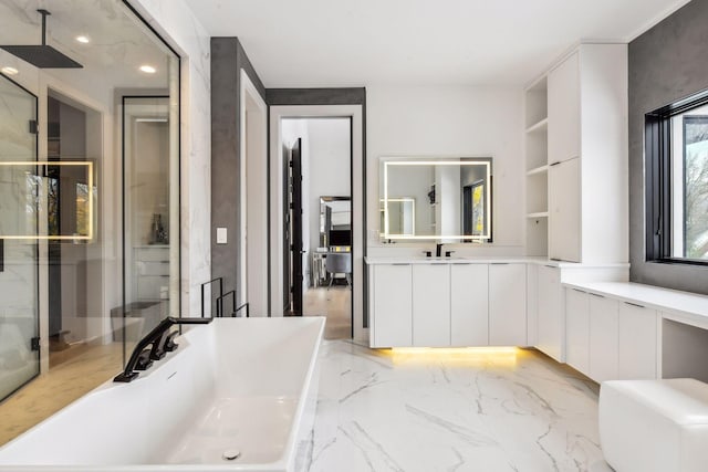 full bathroom featuring vanity, marble finish floor, and a freestanding bath