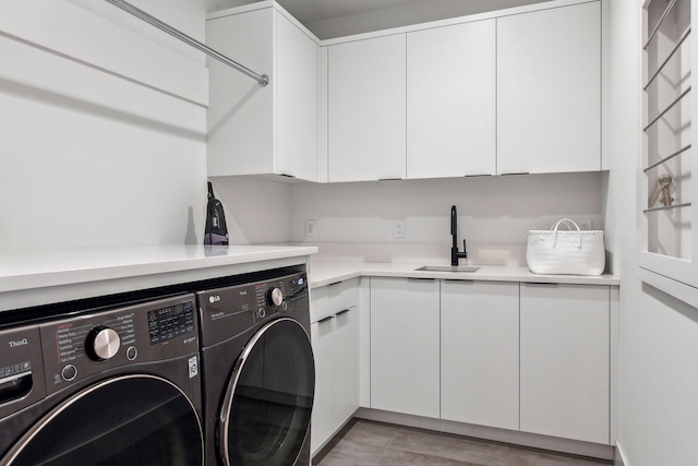 laundry area featuring a sink, cabinet space, and washing machine and clothes dryer