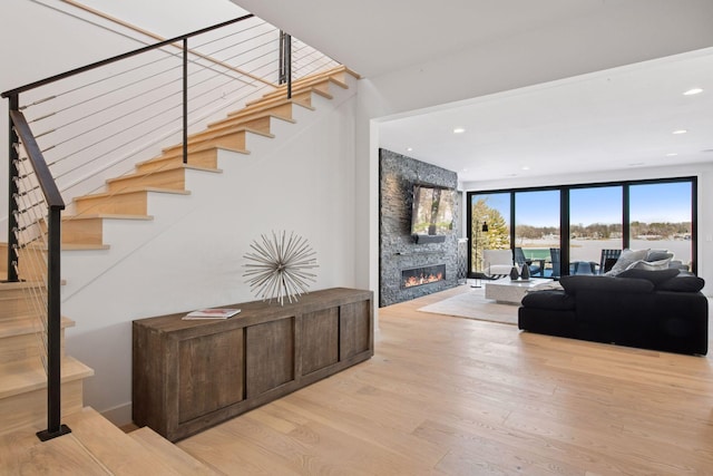 interior space with a fireplace, recessed lighting, and wood finished floors