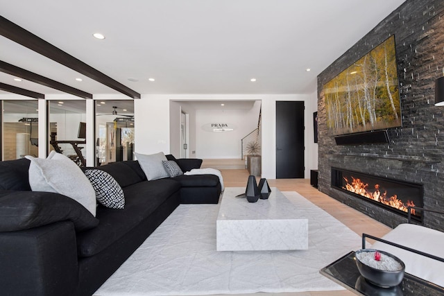 living area with recessed lighting, wood finished floors, and a fireplace