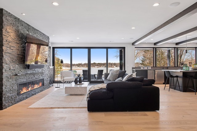 living room with a fireplace, recessed lighting, and light wood-style floors