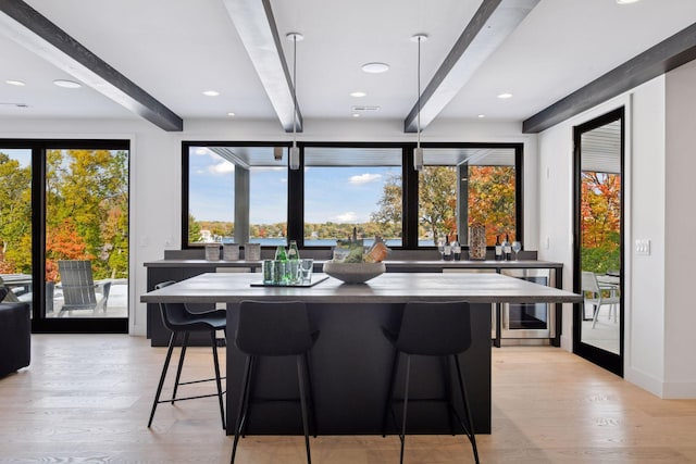 interior space with beamed ceiling, wine cooler, and light wood finished floors