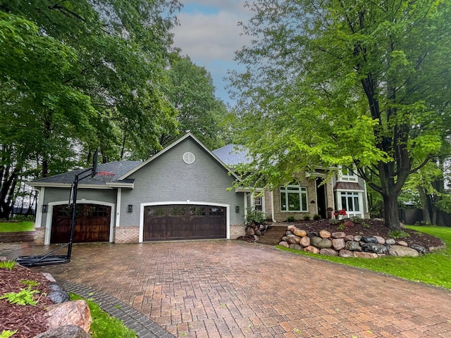 6331 Summit Cir, Chanhassen, MN 55317 - view of front of property featuring a garage, brick siding, decorative driveway, and a shingled roof