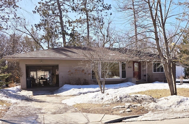 ranch-style home featuring an attached garage and a shingled roof