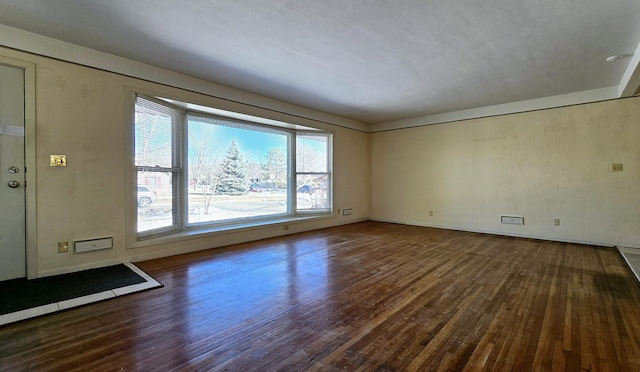 empty room with baseboards and wood finished floors