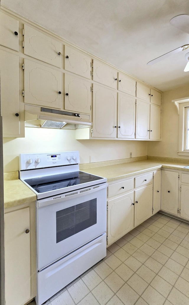 kitchen featuring light countertops, a ceiling fan, under cabinet range hood, and white electric stove