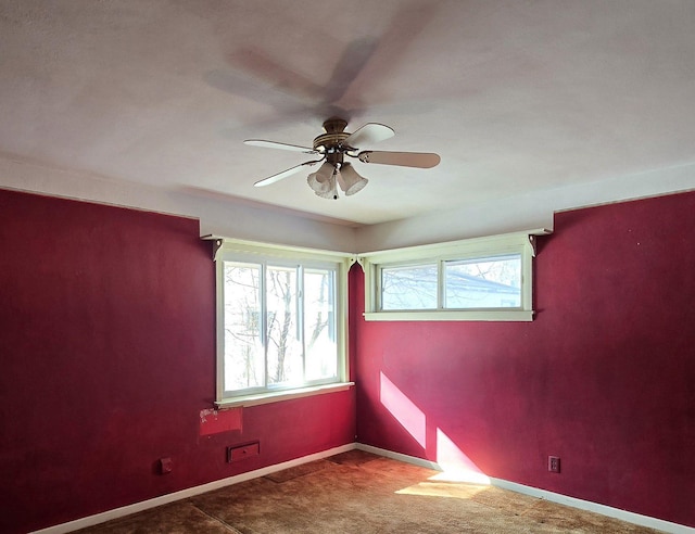 spare room featuring ceiling fan, carpet, and baseboards