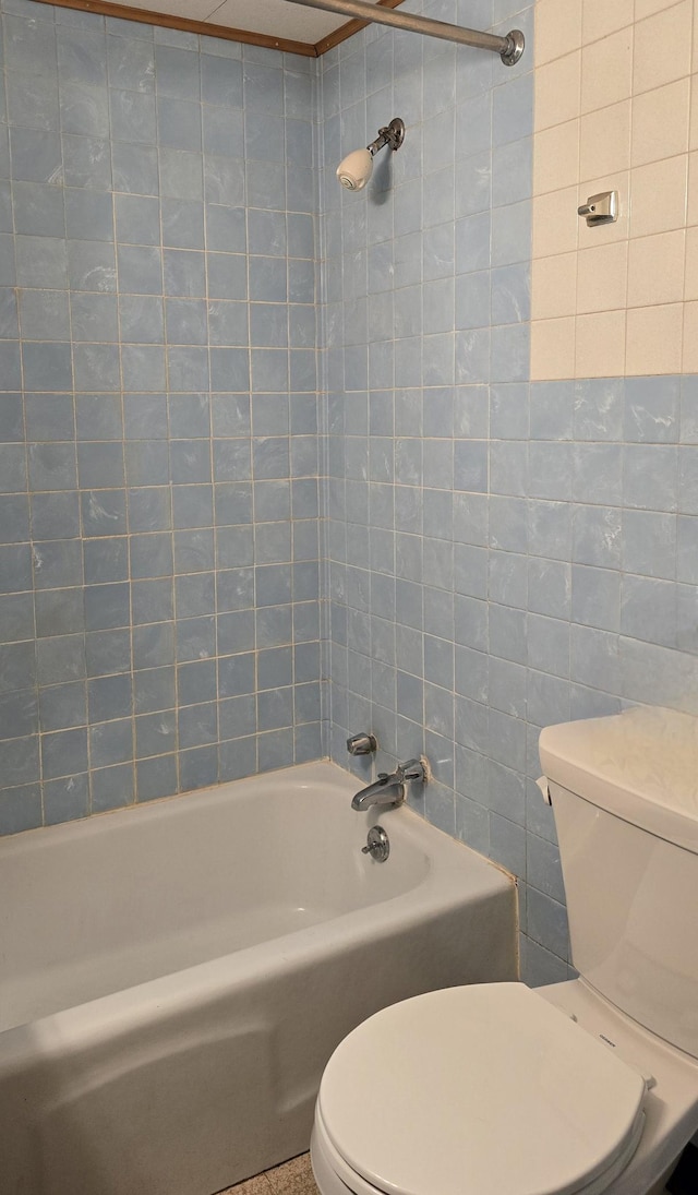 bathroom featuring tile walls, toilet, and bathing tub / shower combination