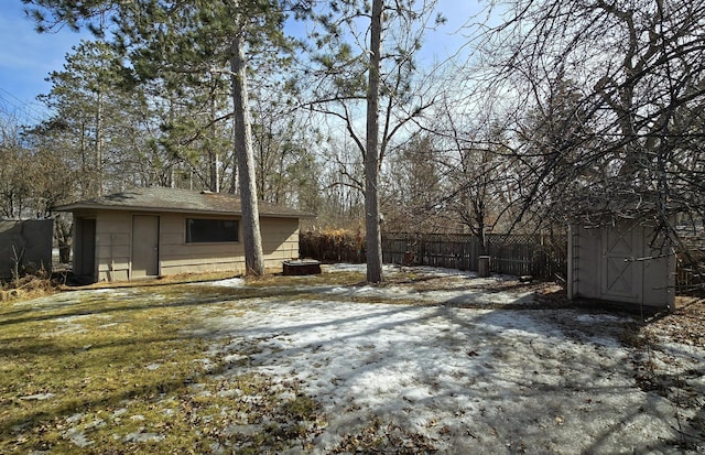 view of yard featuring an outbuilding, a shed, and fence