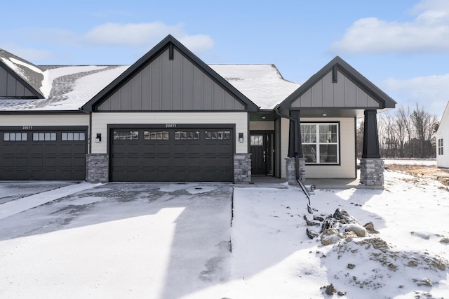 view of front facade with stone siding, board and batten siding, and an attached garage