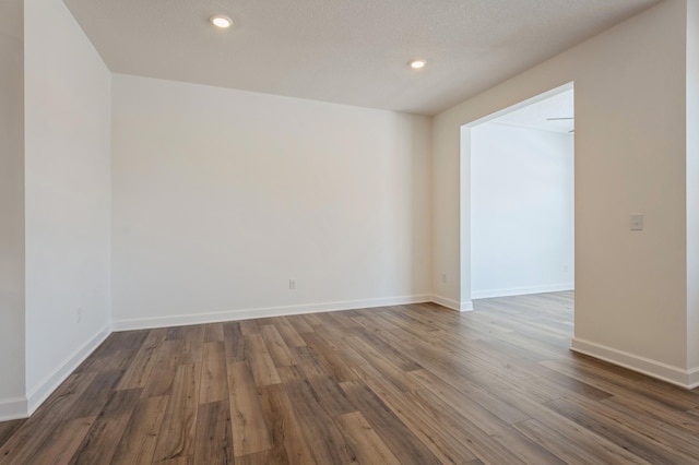 spare room with recessed lighting, wood finished floors, and baseboards