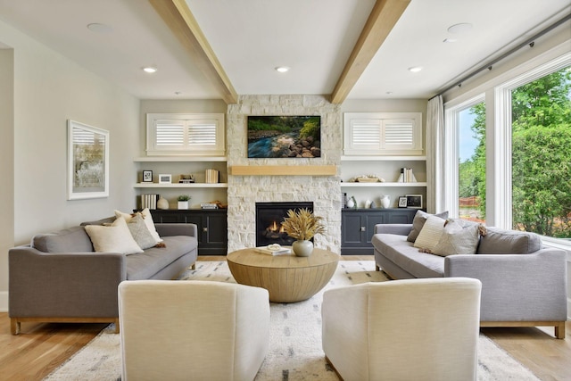 living room with beam ceiling, recessed lighting, a fireplace, and wood finished floors