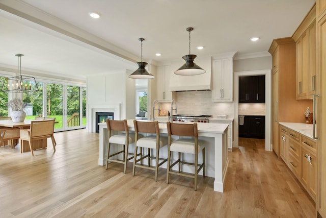 kitchen with decorative backsplash, light wood-style flooring, a breakfast bar area, and a wealth of natural light