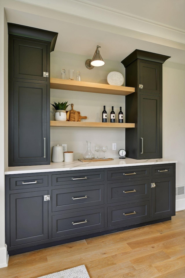 bar featuring light wood finished floors and a bar